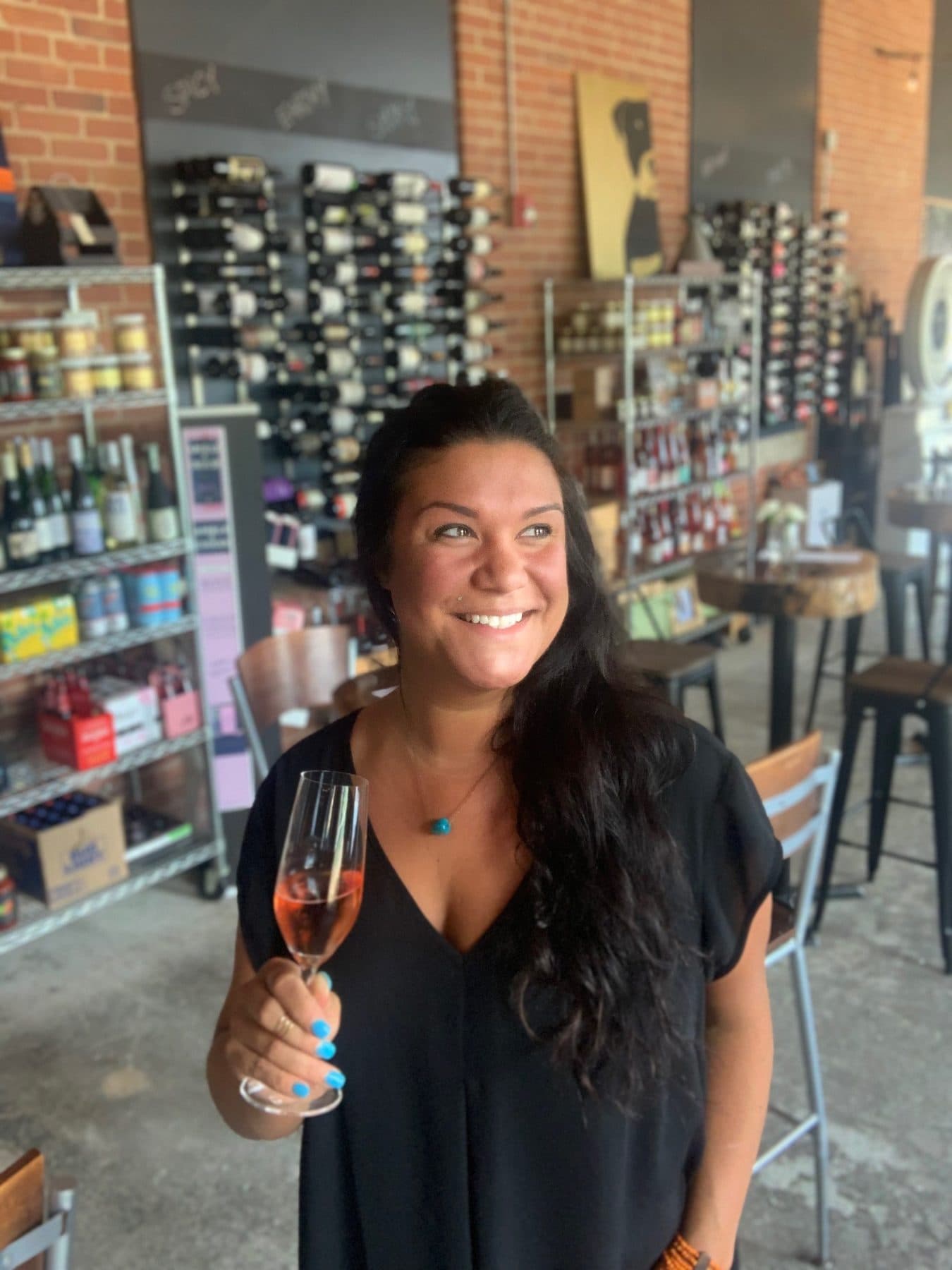 Rochelle, owner of Vin Master, with a glass of rosé in the shop in Charlotte NC